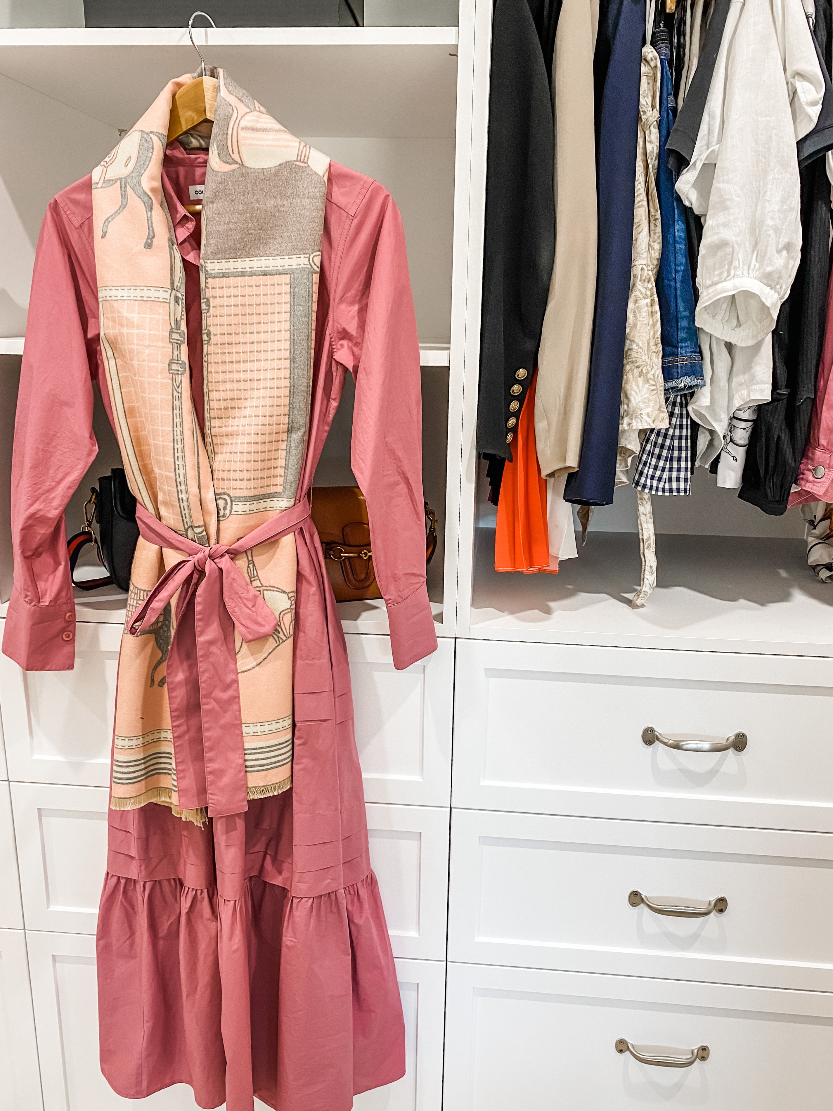 Pink scarf shown with a pink dress hanging in a robe.